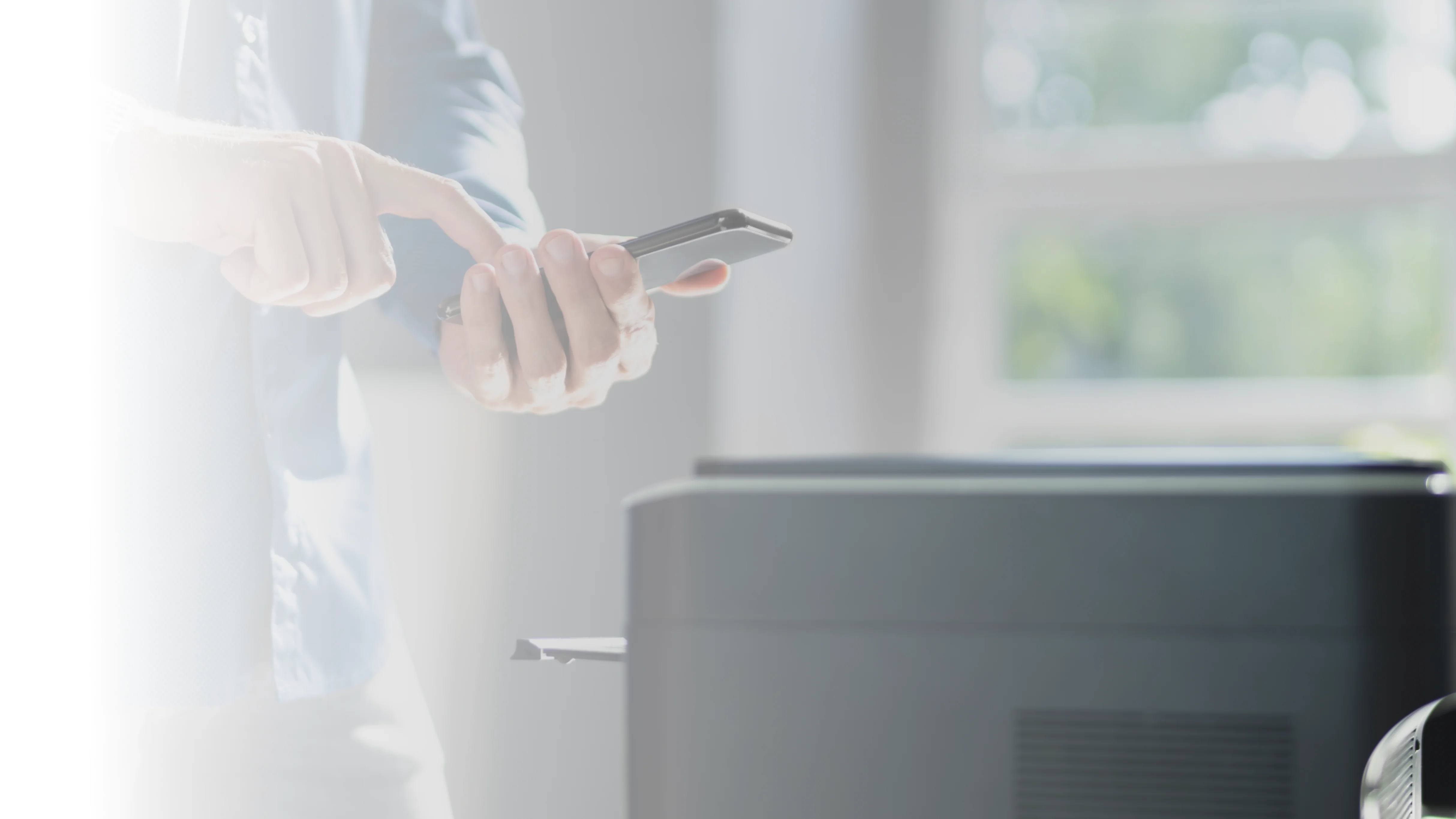 A Person using a smartphone to initiate cloud printing on a wireless printer.